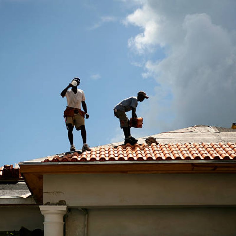 Men working on roof on hot day.